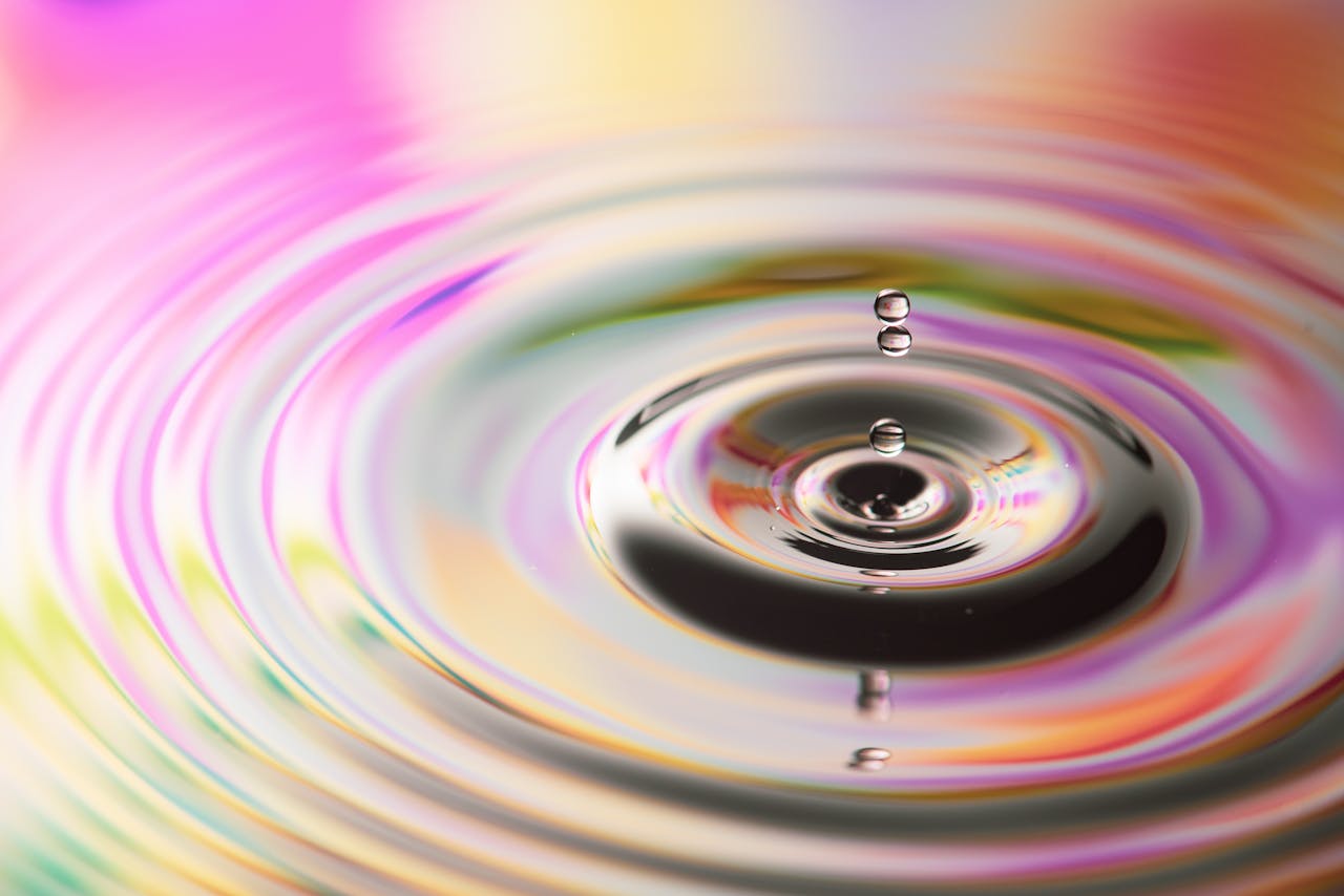 Close-up of water ripples with vibrant colorful reflections creating a mesmerizing pattern.
